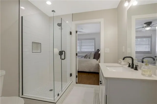 a en suite bathroom with a shower sink and mirror