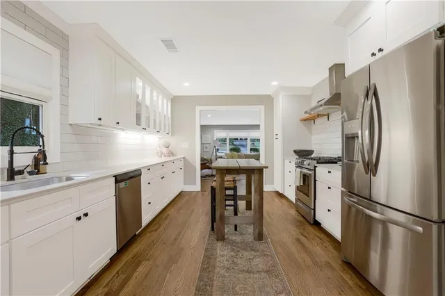 a kitchen with white cabinets and white appliances