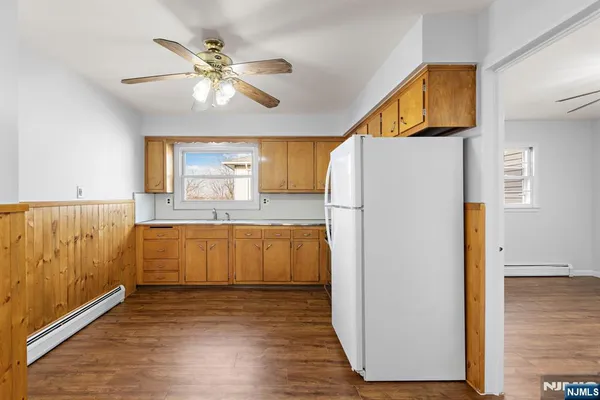 a kitchen with granite countertop a refrigerator a sink and dishwasher