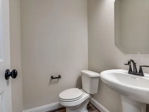 a bathroom with a toilet a sink and mirror