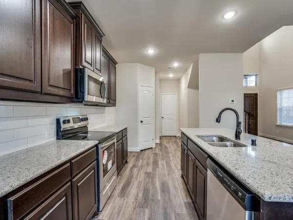 a kitchen with granite countertop stainless steel appliances and sink