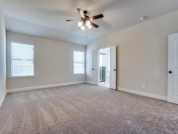 an empty room with fan and windows