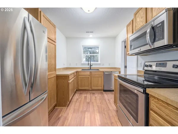 a kitchen with stainless steel appliances a sink cabinets and a refrigerator