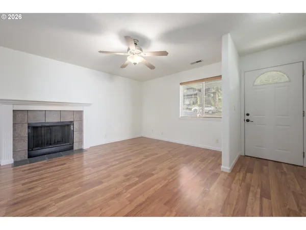 a view of an empty room with a fireplace and a window