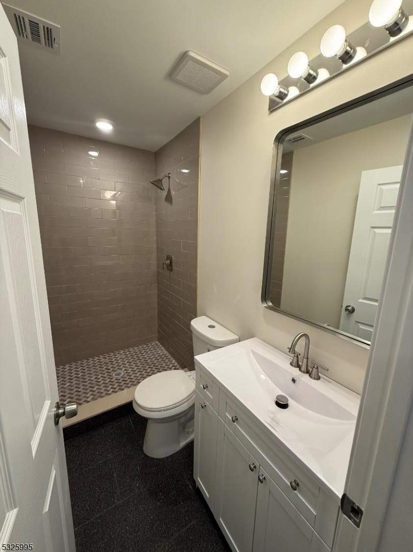 7 Maple Street Bloomfield, NJ 07003 - Photo 12 of 14 a bathroom with a sink a toilet a mirror and shower