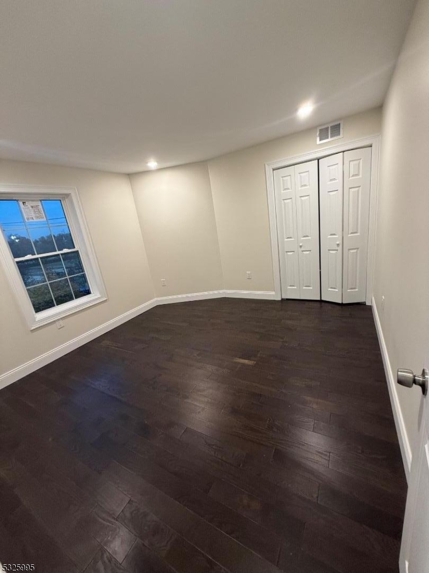 7 Maple Street Bloomfield, NJ 07003 - Photo 7 of 14 an empty room with wooden floor and windows