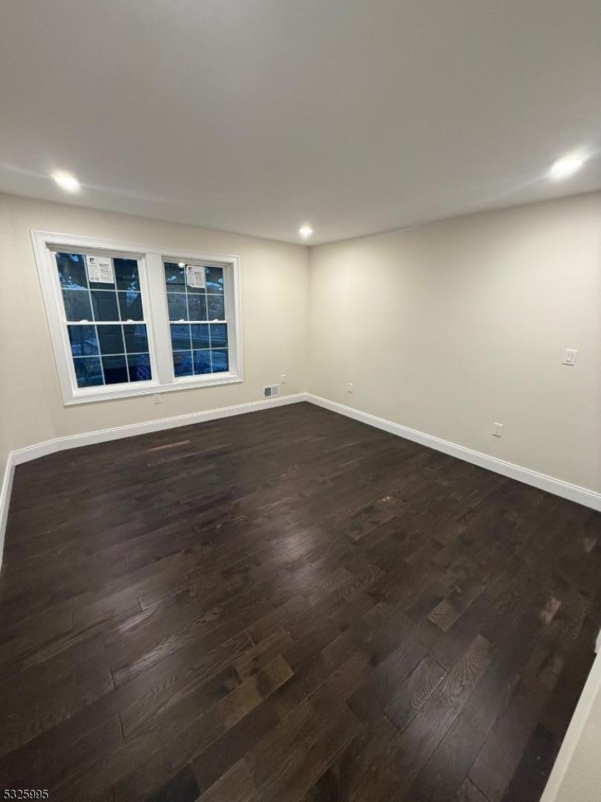 7 Maple Street Bloomfield, NJ 07003 - Photo 10 of 14 an empty room with wooden floor and windows