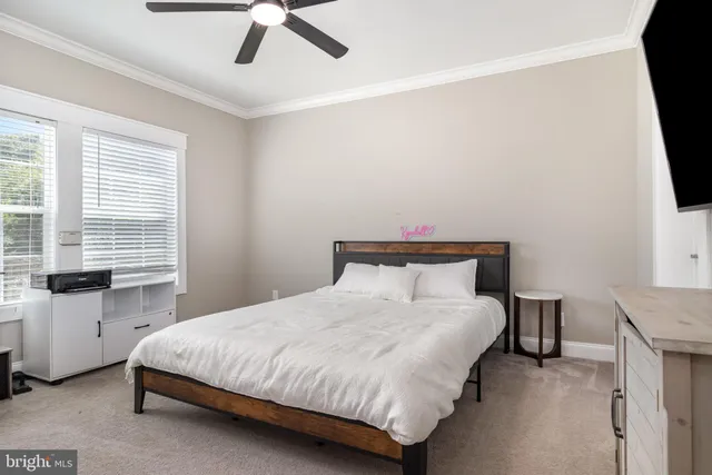 a bedroom with a bed and a flat tv screen on the dresser