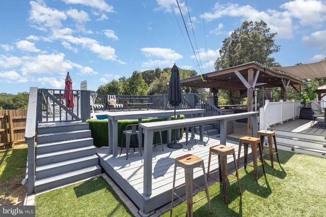 a view of a patio with a table chairs and a small yard