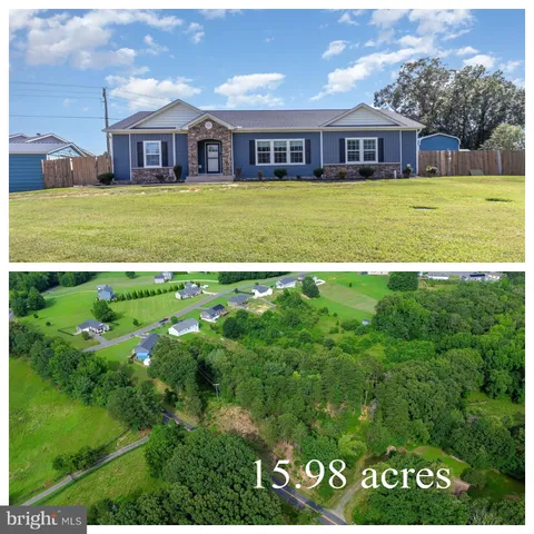 a view of a big house with a big yard and large trees