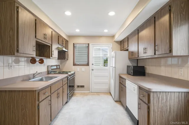 a kitchen with a sink stove top oven and cabinets