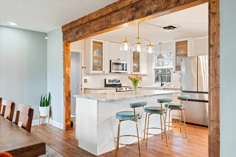 a kitchen with a table chairs refrigerator and cabinets