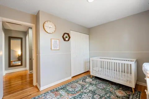 a view of a hallway with entryway and wooden floor