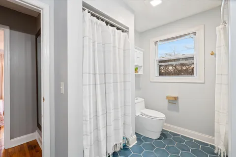 a bathroom with a toilet and a shower curtain