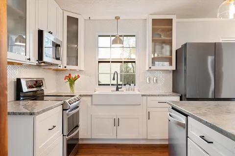 a kitchen with stainless steel appliances granite countertop a refrigerator and a stove top oven