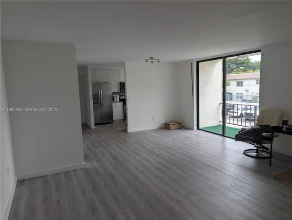 a view of a room with wooden floor and a window