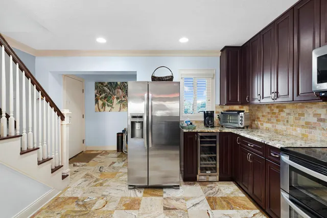 a kitchen with stainless steel appliances granite countertop a stove a sink and a refrigerator