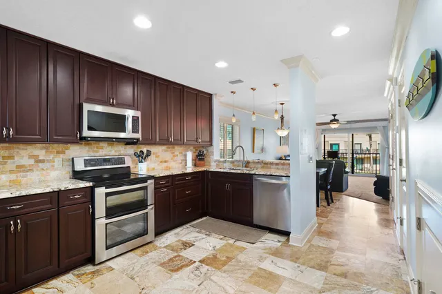 a kitchen with stainless steel appliances granite countertop wooden cabinets a stove top oven a sink and dishwasher