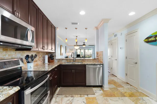 a kitchen with stainless steel appliances granite countertop a stove a sink and a microwave