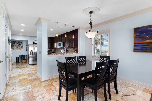 a view of a dining room and livingroom with furniture wooden floor a chandelier