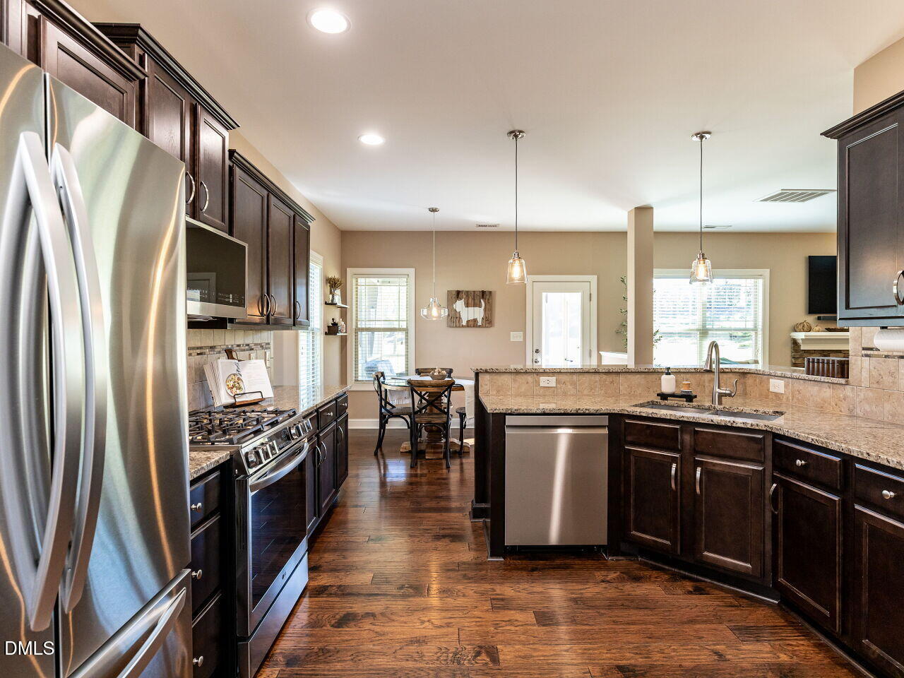 742 Adams Point Drive Garner, NC 27529 - Photo 6 of 31 a kitchen with stainless steel appliances granite countertop a sink stove and refrigerator
