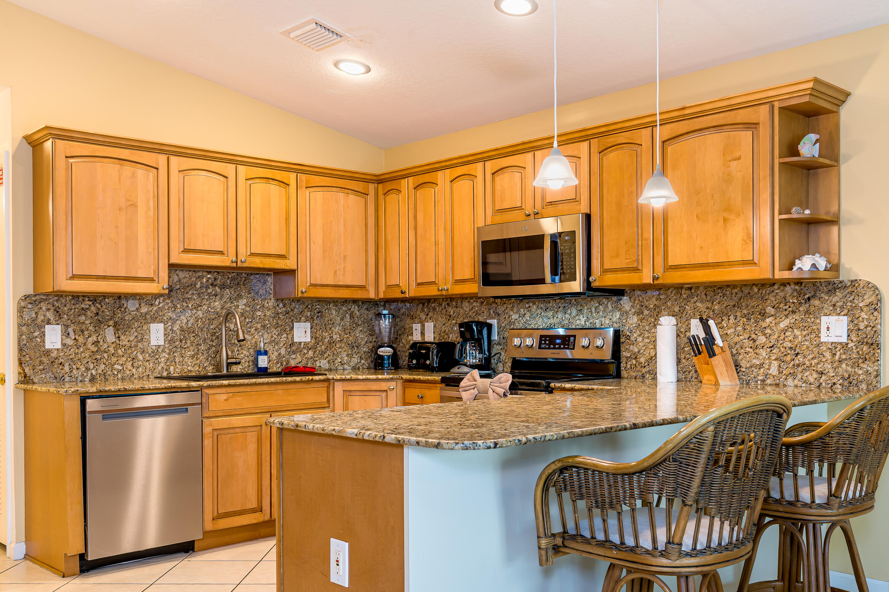 260 Sadowski Causeway Key Colony Beach, FL 33051 - Photo 6 of 50 a kitchen with stainless steel appliances granite countertop a sink a stove a microwave a dining table and chairs