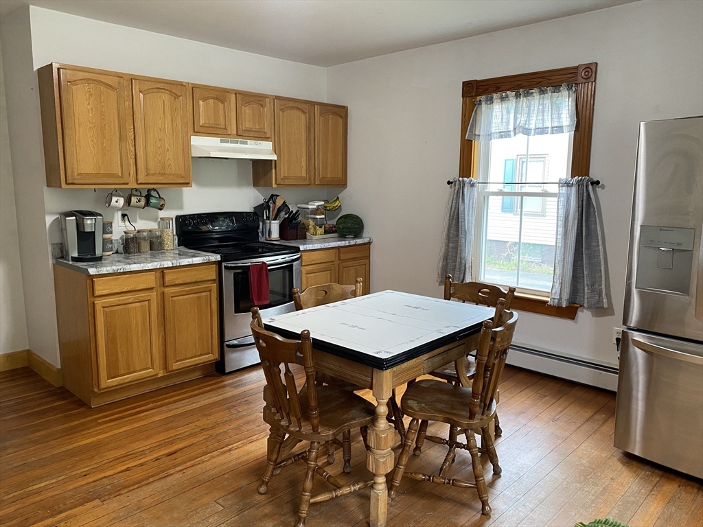 49-51 North Street Three Rivers, MA 01080 - Photo 8 of 21 a kitchen with stainless steel appliances kitchen island granite countertop wooden floors and wooden cabinets