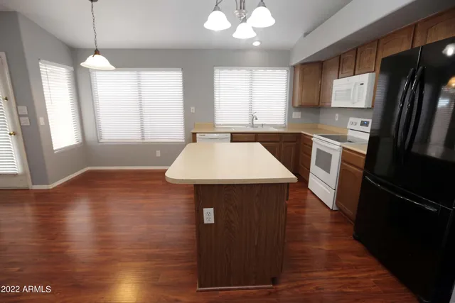 a kitchen with a sink a refrigerator freezer a stove and a window