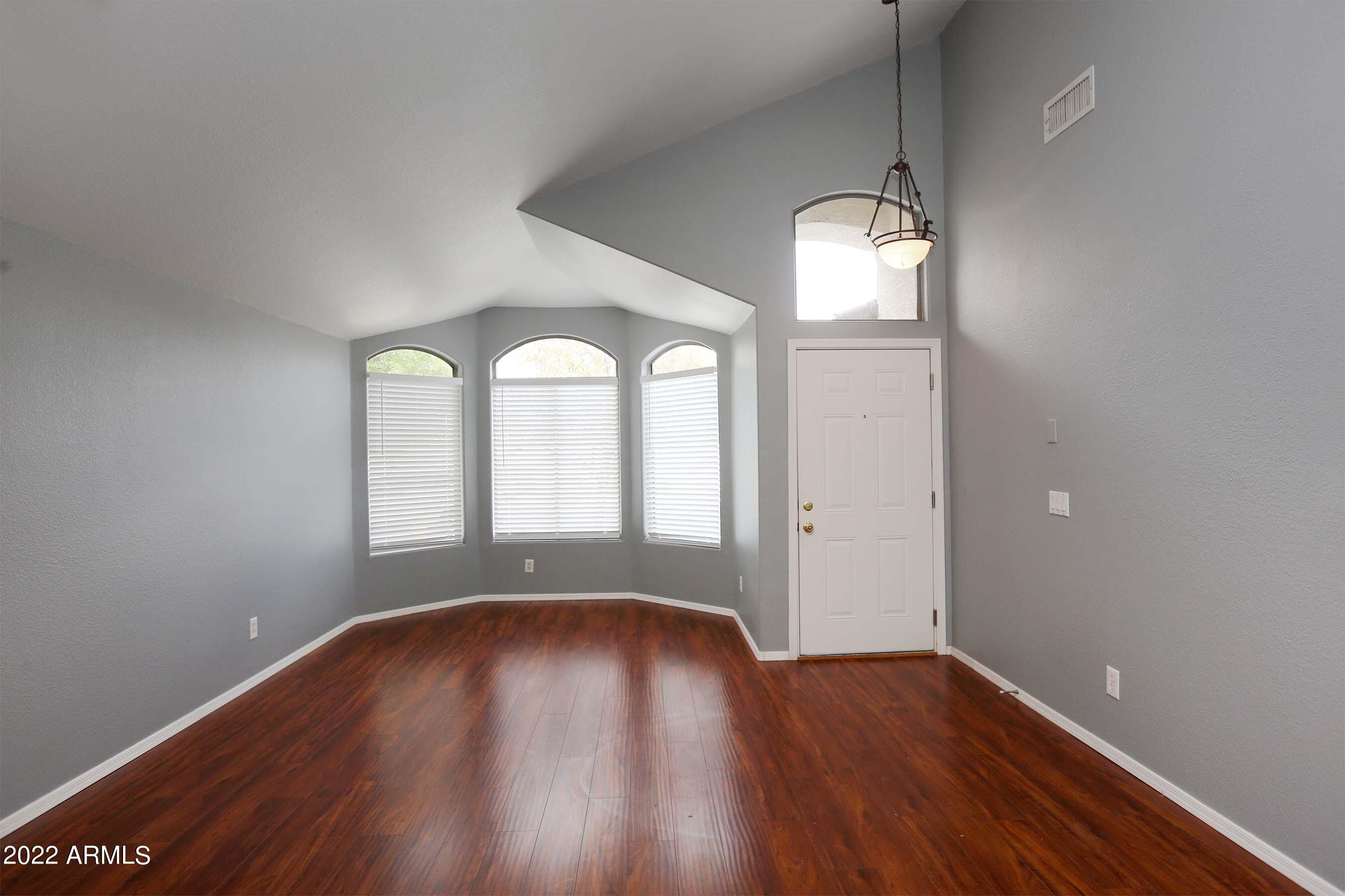 11217 West Edgemont Avenue Avondale, AZ 85392 - Photo 7 of 47 an empty room with wooden floor and windows