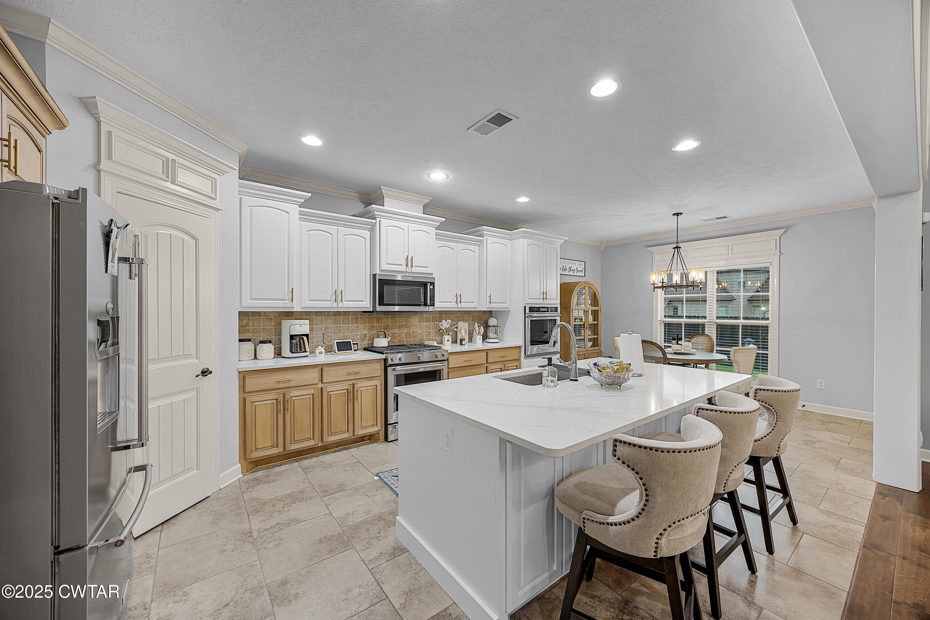 31 Perrington Cove Jackson, TN 38305 - Photo 10 of 27 a kitchen with a sink a stove a refrigerator and white cabinets with wooden floor