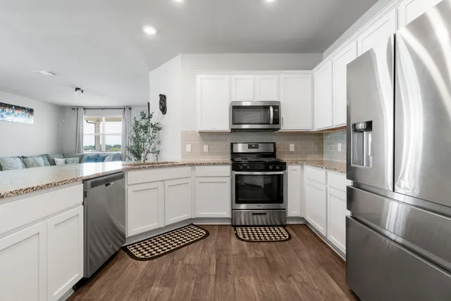 a kitchen with a refrigerator stainless steel appliances a sink and cabinets