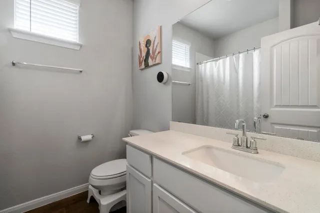 a bathroom with a sink a toilet and a mirror