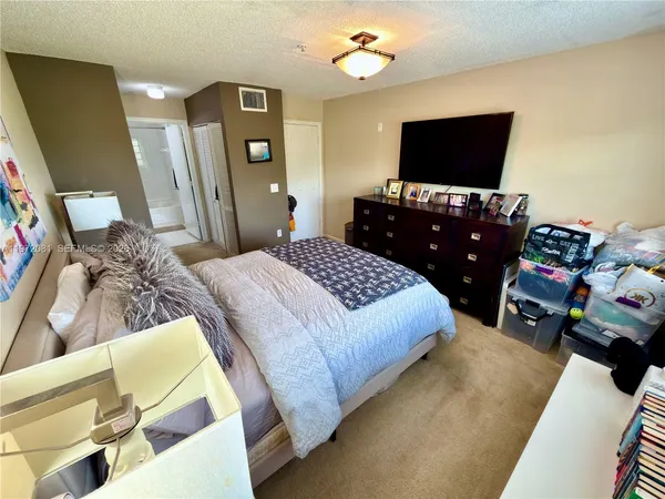a bedroom with a bed and flat screen tv