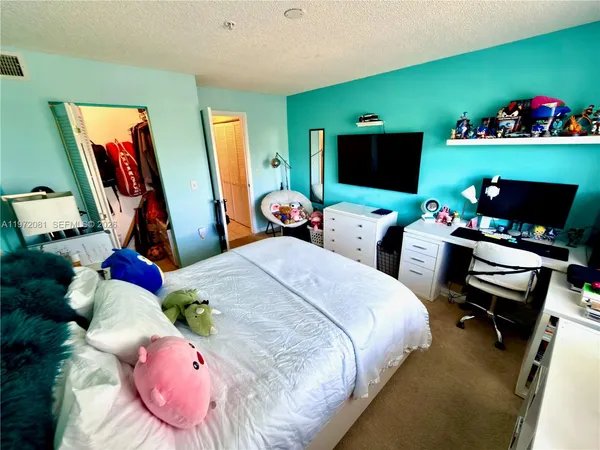 a bed room with a bed window and a flat screen tv