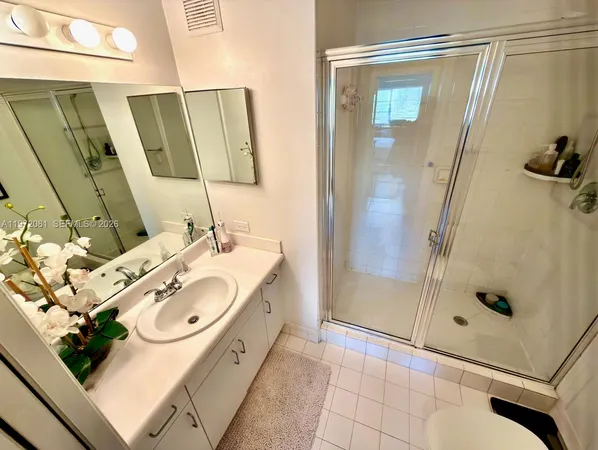 a bathroom with a sink and mirror with bathtub