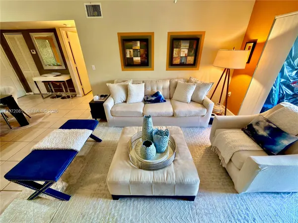 a living room with furniture rug and lamp