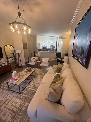a living room with furniture a chandelier and a rug