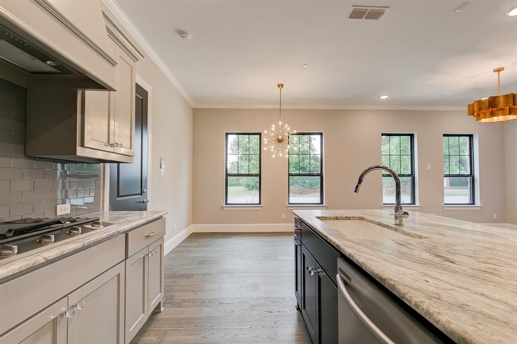 a kitchen with granite countertop kitchen island a sink appliances cabinets and a counter top space