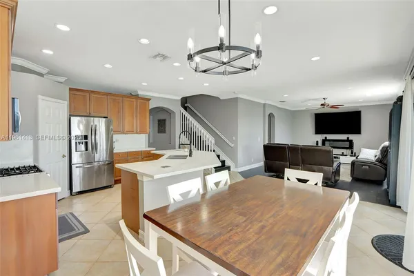 a kitchen with stainless steel appliances kitchen island granite countertop a sink and chairs