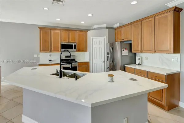 a kitchen with stainless steel appliances a stove refrigerator sink and cabinets