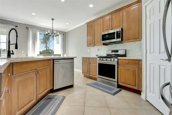a kitchen with stainless steel appliances granite countertop a stove a sink and a microwave
