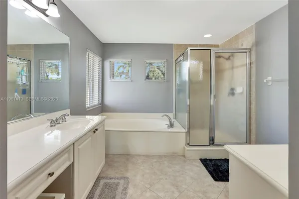 a bathroom with a tub sink and mirror
