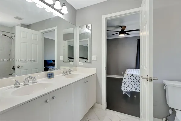 a bathroom with a double vanity sink mirror and toilet