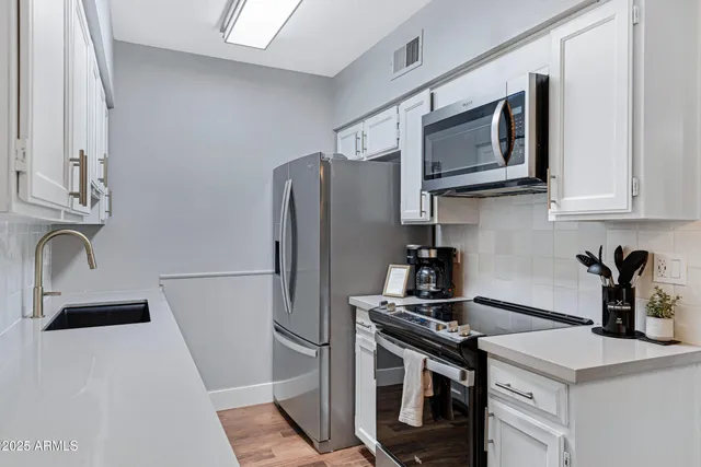 a kitchen with stainless steel appliances granite countertop a sink stove and refrigerator