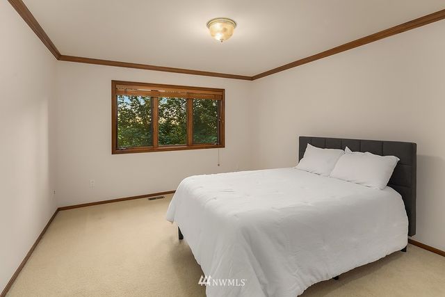 a large bed sitting in a bedroom next to a window