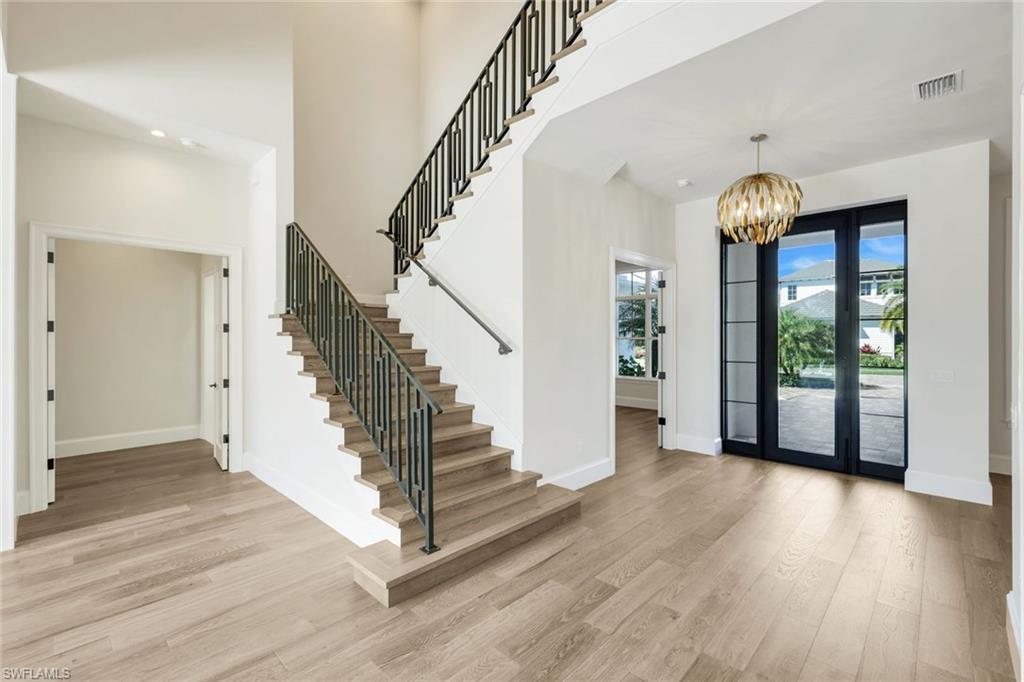 16716 Enclave Circle Naples, FL 34110 - Photo 21 of 50 Entrance foyer featuring light wood finished floors, hanging lights, and a high ceiling