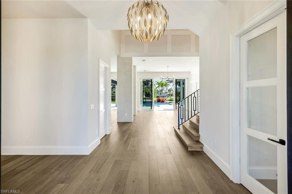 16716 Enclave Circle Naples, FL 34110 - Photo 23 of 50 Foyer entrance with a chandelier, dark wood-type flooring, and a high ceiling