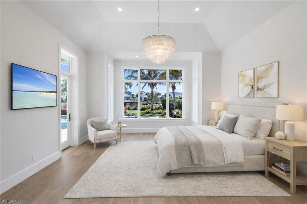 16716 Enclave Circle Naples, FL 34110 - Photo 30 of 50 Bedroom featuring access to outside, light wood-style flooring, suspended lighting, and vaulted ceiling