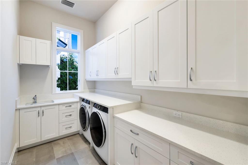 16716 Enclave Circle Naples, FL 34110 - Photo 45 of 50 Laundry area with cabinet space, independent washer and dryer, and light tile patterned flooring