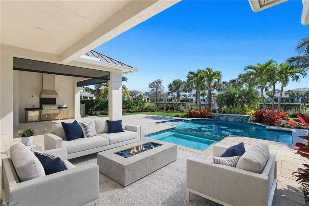 16716 Enclave Circle Naples, FL 34110 - Photo 6 of 50 Combined pool / hot tub with an outdoor kitchen with living area, a patio area, and an outdoor fire pit